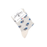 Détail du motif oiseaux gris et branches noires sur chaussette femme blanche.