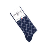 Chaussette homme haute bleu marine à motifs géométriques blancs avec packaging Maison Broussaud.