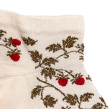 Détail motif fraises rouges et feuillage doré sur chaussette femme invisible blanche.