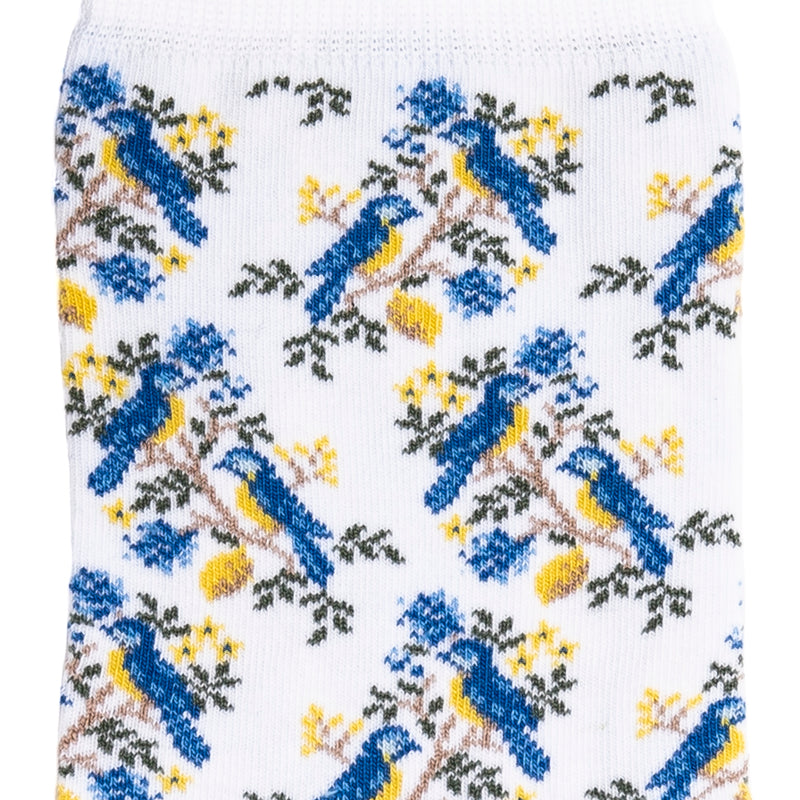 Détail motif oiseaux bleus et jaunes sur chaussette femme mi-haute blanche.