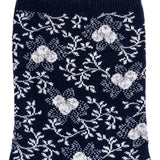Détail du motif floral blanc sur chaussette femme moyenne bleu marine.